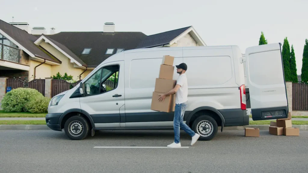 Delivery driver carrying packages from a van during a Black Friday side hustle, representing package delivery jobs.